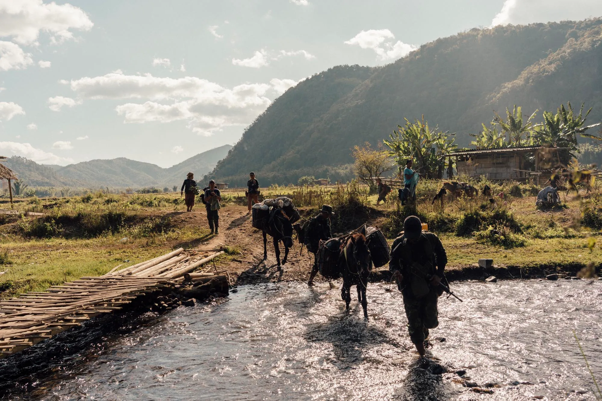 Free Burma Rangers crossing a river with pack horses in the mountains of Burma